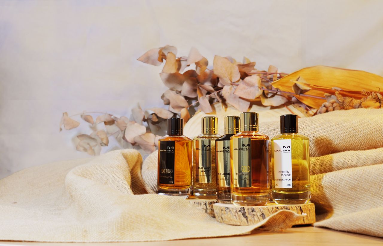 contact-img Aesthetic display of luxury perfume bottles with natural dried botanicals and linen backdrop.