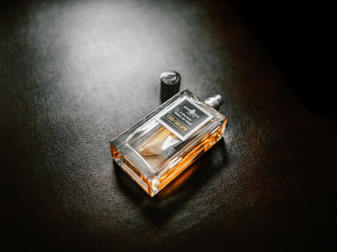 Luxurious perfume bottle with copy space on a textured dark background.