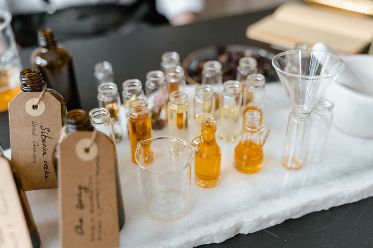 about-img Aromatic essential oils in glass vials on a white surface, arranged for aromatherapy use.